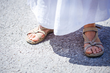 Fototapeta premium woman stands in sandals on the road, detail