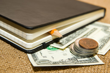 notebook, pencil and money on the old tissue
