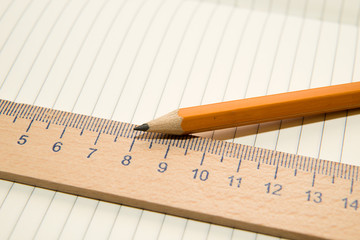 Notepads, pencil and wooden ruler on the old tissue