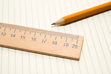 Notepads, pencil and wooden ruler on the old tissue