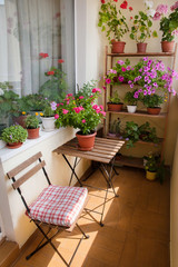 Fototapeta na wymiar Beautiful balcony with small table, chair and flowers.