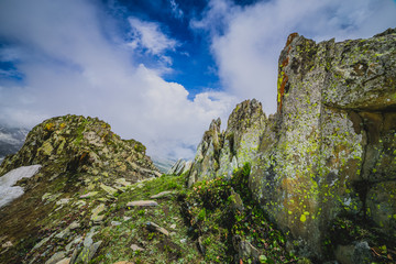 Rocky landscape of with ice peaks and blue cloudy sky in background , green valley , Ladakh, Jammu and Kashmir, India