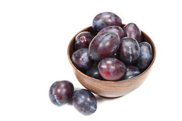 Fresh plums in a bowl on white background.