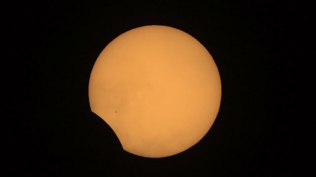 Sun eclipse from the 20.03.2015. with passing clouds - Moon silhouette exiting sun disk. Taken trough my telescope with 1000mm focal length. In the lower left center can be seen a group of sunspots.
