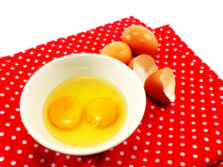 broken eggshells with egg yolks in ceramic bowl