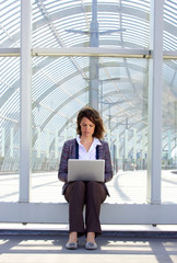 Fototapeta premium Business woman sitting outside using laptop