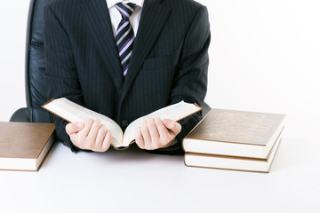 重厚な本を読むビジネスマン