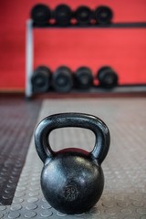 Obraz na płótnie Canvas Close up view of kettlebell in front of dumbbells 