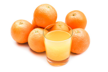 Fizzy orange juice from effervescent tablet with oranges at backdrop