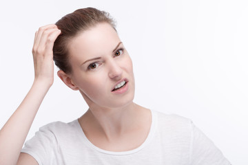 Fototapeta premium Junge hübsche Frau kratzt sich nachdenlich am Kopf
