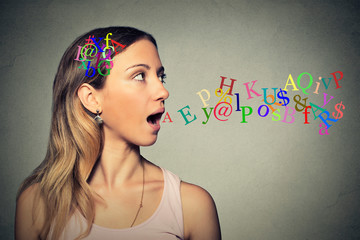 woman talking alphabet letters in her head coming out of open mouth - obrazy, fototapety, plakaty