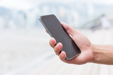 hand holding mobile phone on street