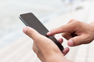 hand holding mobile phone on street