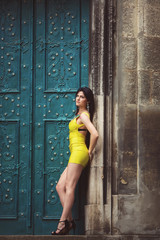 A beautiful woman in a yellow dress, tattoos, leaned behind the