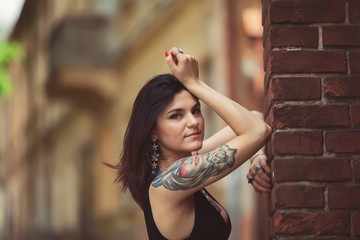 beautiful girl in a black dress stands near architectural struct