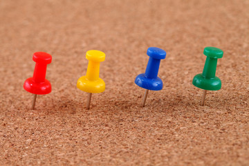pushpins on brown billboard