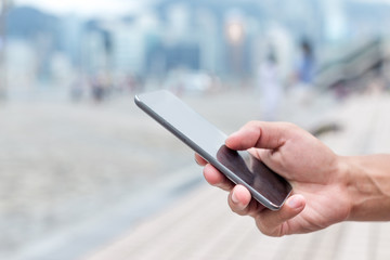 hand holding mobile phone on street