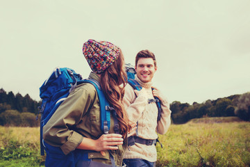 smiling couple with backpacks hiking