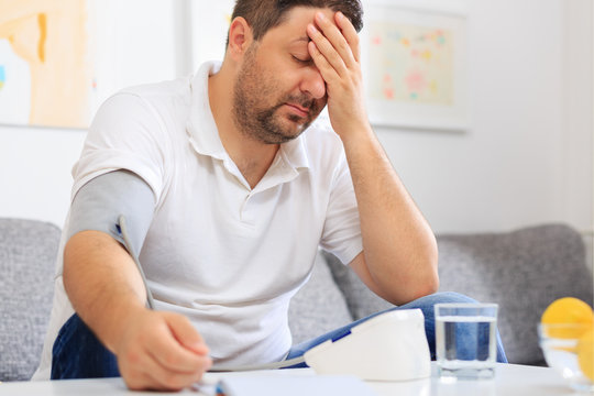 Man Measuring  His Blood Pressure Feeling Sick.