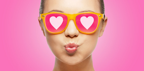 girl in pink sunglasses blowing kiss