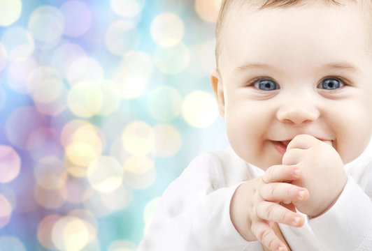 happy baby over blue holidays lights background