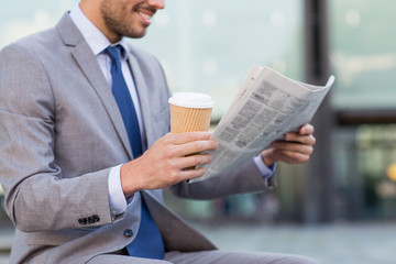 close up of smiling businessman reading newspaper