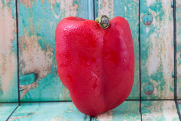 Fresh colorful red bell pepper on a rustic wooden background