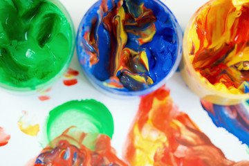 Jars of finger paint on a painting