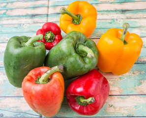 Fresh colorful bell peppers on a rustic wooden background