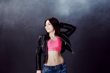 young woman hip hop dancer on the background texture dark wall