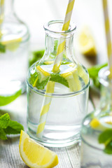 Lemonade with fresh lemon on wooden background