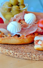 Bruschetta with prosciutto and mozzarella on a wooden table