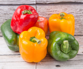 Fresh colorful bell peppers on a rustic wooden background