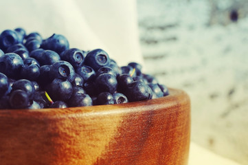 Fresh blueberries in a wooden round plate