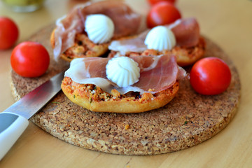 Italian Bruschetta With Mozzarella And Prosciutto On A Wooden Table