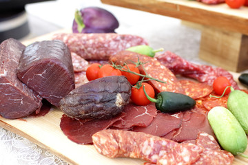 smoked meat products, vegetables on the table