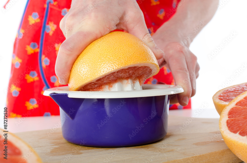 Poster Woman holding a half grapefruit before to squeeze it