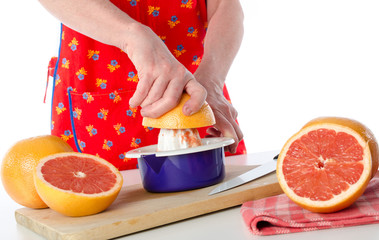 Woman holding a half grapefruit before to squeeze it