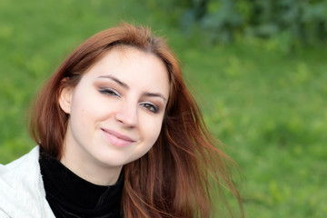 Portrait of red-haired girl in the park