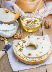 Fresh bagel with cottage cheese, pear, walnut and honey for breakfast. Concept of healthy eating.
