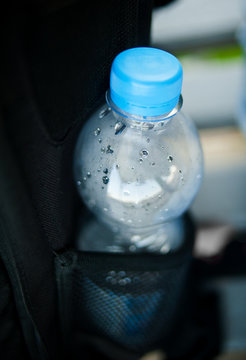 plastic bottle of water in pocket of backpack