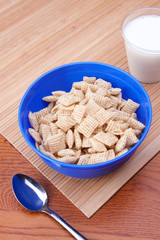 Healthy Rice Cereal Breakfast – A bowl of rice cereal. Glass of milk in background.