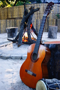 Guitar in the sand by the fire place