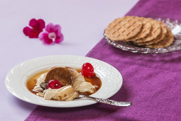 Eating panna cotta with cheries, caramel and wafer