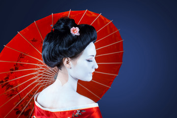 Portrait of a woman in red kimono with umbrella, view from back