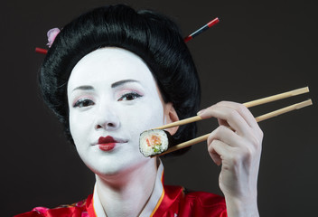 Portrait of a woman in geisha makeup eating sushi