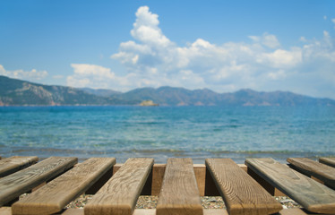 wooden planks at foreground with sea and mountains at background