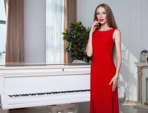 Fashion photo of young magnificent woman in red dress. Studio photo