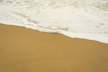 Fototapeta na wymiar Sea wave and many foot print on the beach background
