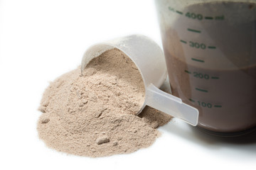 Chocolate protein shake and a scoop of  protein powder  poured o